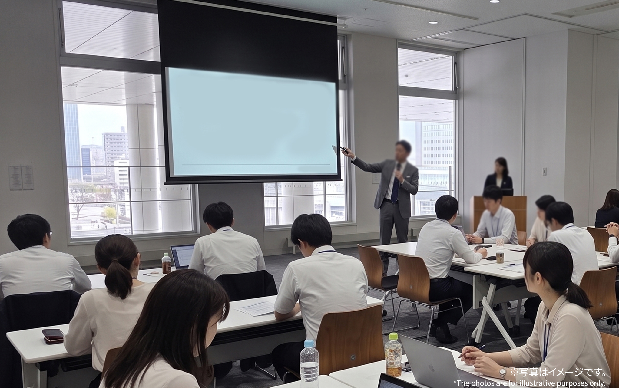 セミナールーム半面を使った社員研修のイメージ。スクリーンにスライドを投影し、講師が解説している。