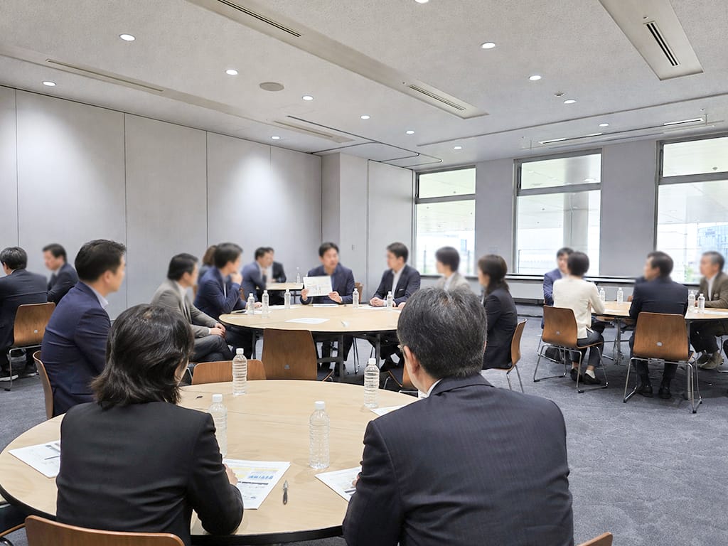 円卓を囲み、資料を確認しながらフランチャイズオーナー会議を行う参加者