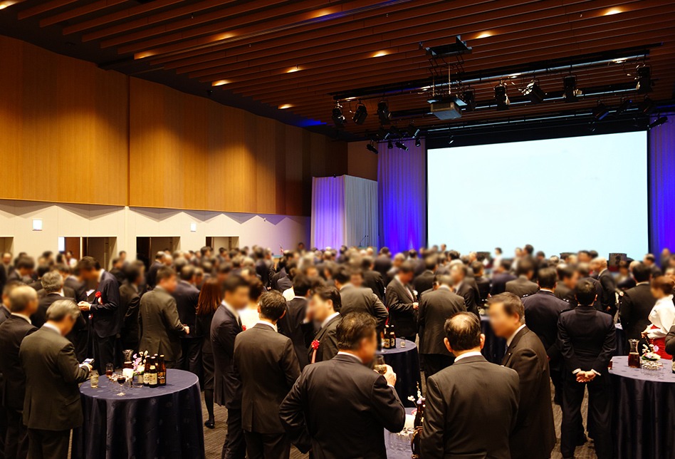 丸テーブルを囲んで大勢の人が談笑している様子