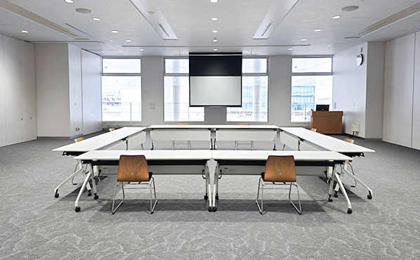 コの字型レイアウトの後方席からプロジェクターとスクリーンを見た様子